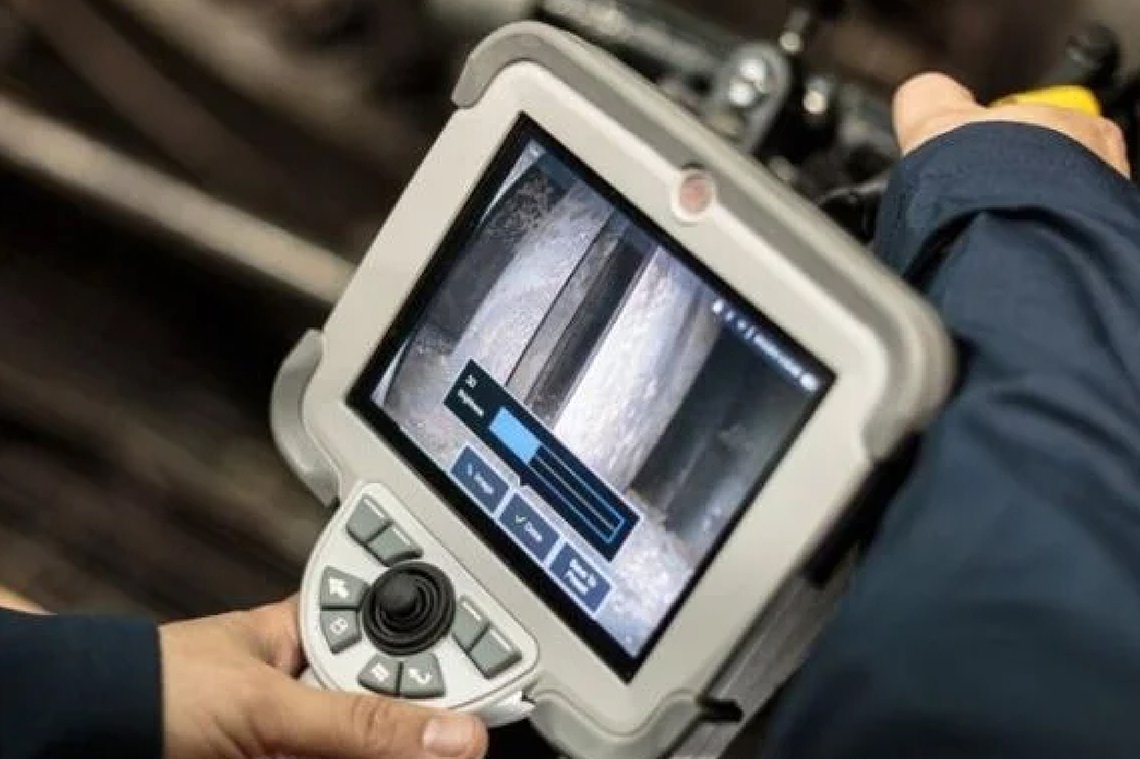 Technician inspecting equipment with a borescope